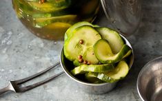 cucumber slices in a metal bowl next to a spoon