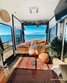 a bedroom with an ocean view and lots of pillows on the bed in front of it