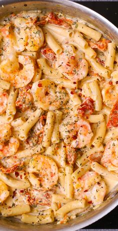 a pan filled with pasta and shrimp covered in sauce