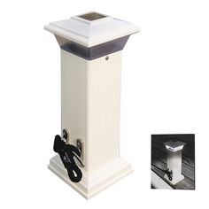 a white post with a black top and an electrical outlet