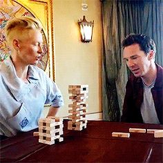 two people playing with wooden blocks on a table