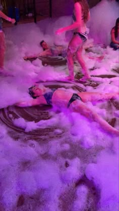 two women in bathing suits are surrounded by foam