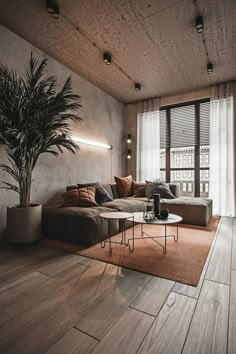 a living room filled with furniture and a large window covered in shades of grey, brown and white