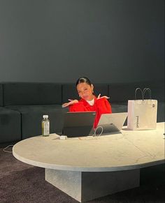 a woman sitting at a table with a laptop