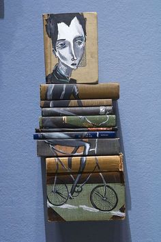 a stack of folded books sitting on top of a blue wall