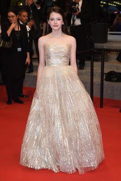 a woman standing on top of a red carpet