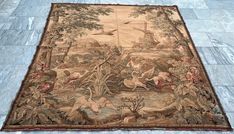 an old rug with birds and animals on it in the middle of a tile floor