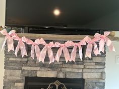 a fireplace decorated with pink bows and a flat screen tv