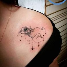 a woman's shoulder with an anchor and heart tattoo on her left side breast