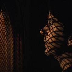 a man with his face covered by a black and white checkered cloth in the dark