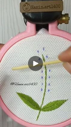 someone is stitching a flower with a needle