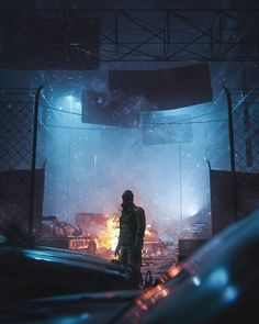 a man standing in the middle of a parking lot next to a bunch of cars