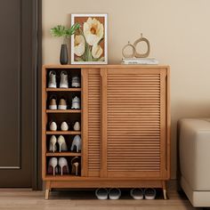 a wooden cabinet with shoes on it next to a couch