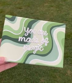 someone is holding up a card with the words you are made of magic on it