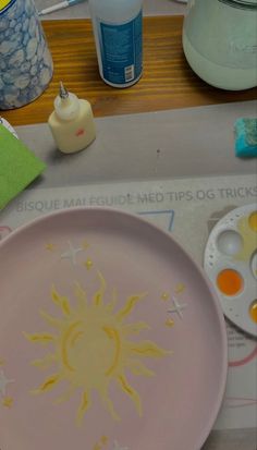 a pink plate with yellow sun and stars painted on it