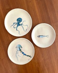 three plates with designs on them sitting on a table