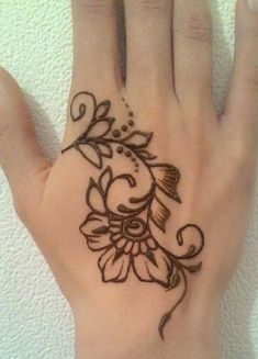 a person's hand with a flower tattoo on the left side of their palm