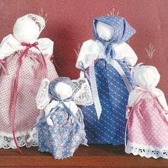 three little dolls are sitting on a shelf