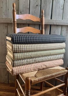 a stack of blankets sitting on top of a wooden chair