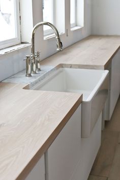 a kitchen with white counter tops and wooden counters in front of a window that reads diy butcher block countertops