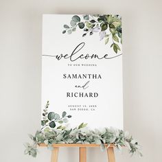 a welcome sign with greenery on it