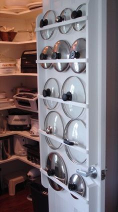 an open refrigerator filled with lots of plates and pans on it's shelves