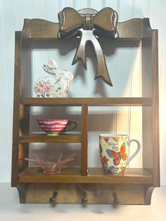 a wooden shelf with cups and saucers on it