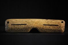 a piece of wood with holes in it on a black background and the image is made out of clay