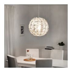 a white dining room table and chairs with a light fixture hanging over it's head