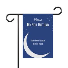 a blue and white flag with the words do not disturb on it, hanging from a black pole