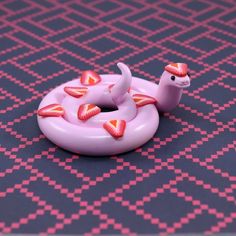 an inflatable toy with hearts on it laying on a patterned tablecloth,