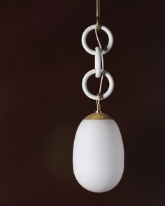 a white light hanging from a gold colored metal hook on a dark background with circles and rings