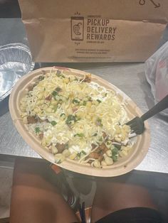 a pizza sitting on top of a pan covered in cheese and toppings next to a person's legs