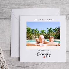 a card with an image of two people laying on the ground next to a pool