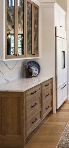 a large kitchen with wooden cabinets and marble counter tops, along with an area rug on the floor