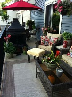 a patio with chairs, tables and an umbrella over the fire place on top of it