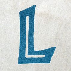 the letter l is drawn on a piece of white paper with blue stencils