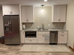 a kitchen with stainless steel appliances and white cabinets