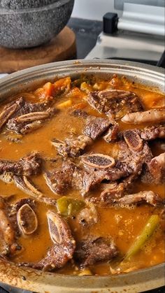 a pan filled with meat and vegetables on top of a stove