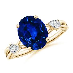 an oval blue sapphire and diamond ring with two diamonds on the band, set in yellow gold