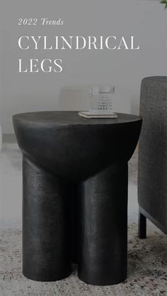 there is a black round table in the middle of this room with text overlay that reads, 2009 trends cylindrical legs