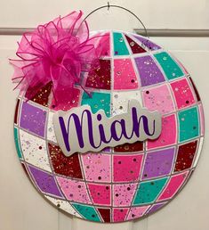 a colorful door hanger with the name miah on it and a pink bow