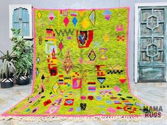 a bright green rug with colorful designs on the front and back, sitting next to potted plants