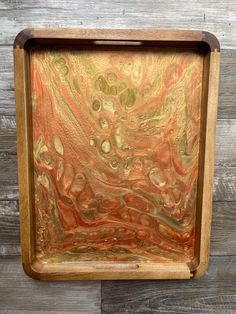 a wooden box with gold and red paint on the inside, sitting against a wood wall