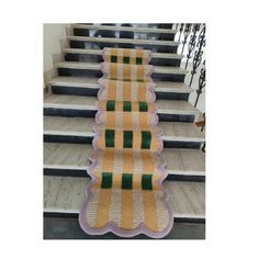 a stair runner with green and white stripes on it, along with some stairs in the background