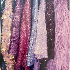 there are many different colored sequins hanging on the rack together in this photo