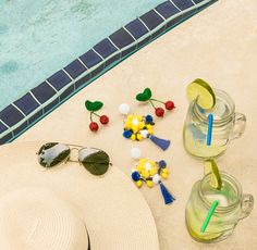 a hat, sunglasses and other items near a swimming pool