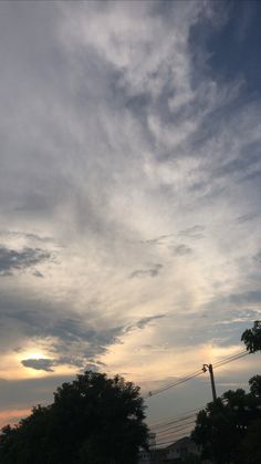 the sky is filled with clouds and trees