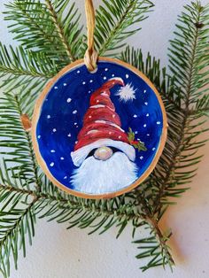 a christmas ornament hanging from a pine tree with snow and stars on it