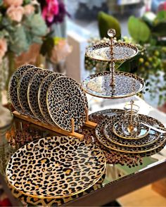 a table topped with plates and trays filled with different types of animal print dishes